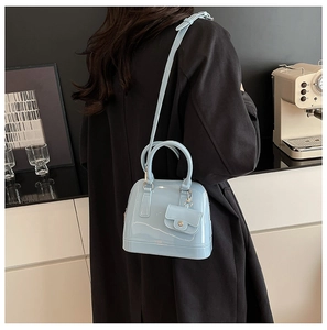 Light blue jelly shoulder bag with mini purse charm shown on model back view