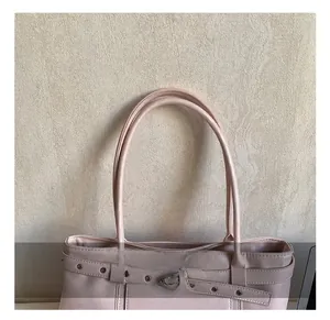 Détail du sac cabas rose avec poignées rondes et boucles à rivets métalliques