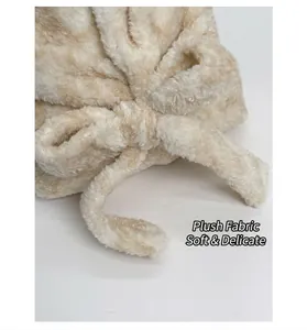 Dettaglio ravvicinato del tessuto felpato beige con morbida ecopelliccia e fiocco