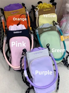 Flat lay of colorful nylon drawstring phone bags in orange, yellow, pink, green, and purple