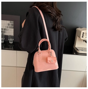 Pink jelly shoulder bag with matching mini pouch accessory on a shoulder view