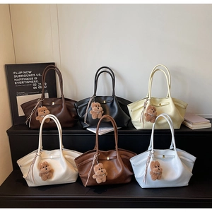 Detailed display of tote bags in six colors featuring plush bear charms and tassels