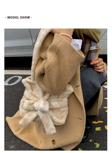 Detail of plush tote bag with large bow and textured shoulder strap in apricot