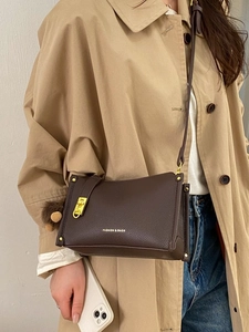 Brown lychee leather Boston handbag for women with gold hardware and pompom charm