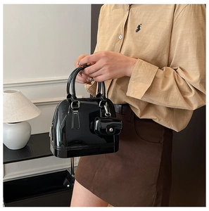 Detail of a black glossy jelly handbag with a matching mini zip coin purse accessory