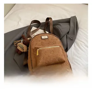 Detailansicht der geprägten braunen Kunstlederstruktur und des Vintage Bären-Anhängers