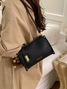 Chic black litchi pattern handbag with gold hardware and a cute brown plush charm