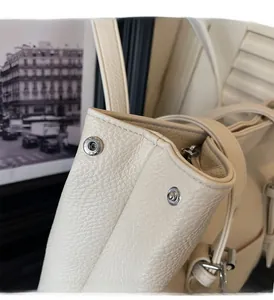 Détail du cuir grainé crème avec boucle magnétique en argent poli élégante