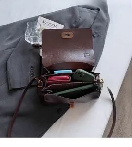 Detailed interior of vintage brown faux leather bag showing three functional compartments