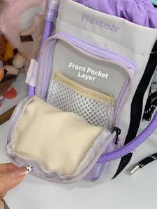 Detailed interior of purple crossbody bag front pocket with beige mesh compartment