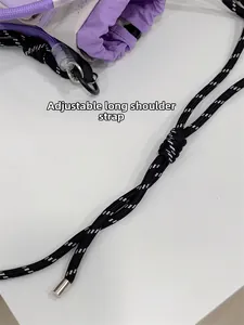Close-up of adjustable black and white woven rope shoulder strap with silver metal tips