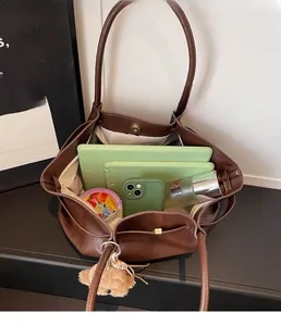Top view of large brown leather tote bag interior showing ample storage for iPad and bottle