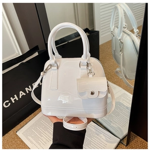 Detail of white glossy jelly shell bag showing waterproof texture and small pouch attachment