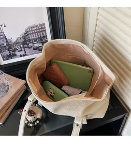 Vue de dessus du grand sac cabas crème avec cuir litchi et pendentif en peluche