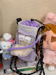 Detail of a lavender and grey nylon bucket bag with a cute cat-shaped plush decoration