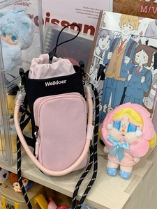 Detail of pink and black crossbody phone bag with drawstring and adjustable rope strap