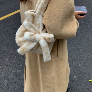 Detail of soft plush tote bag featuring a large decorative bow in apricot spotted faux fur