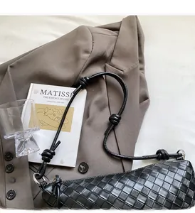 Détail du sac à bandoulière en cuir tressé noir avec bandoulière à nœuds chic