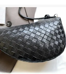 Détail du sac croissant tissé noir avec artisanat en cuir tressé à grille carrée