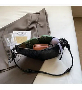 Détail de l'intérieur du sac hobo tressé noir montrant la capacité pour téléphone et portefeuille