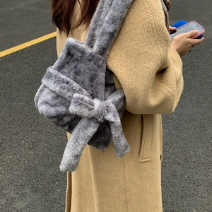 Detail of grey faux fur tote bag featuring a large decorative plush bow on the side