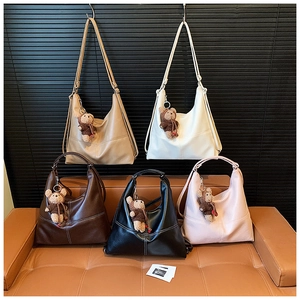 Detailed arrangement of diverse hobo shoulder bags with cute teddy bear charms