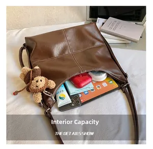 Detail view of large capacity vintage tote bag with interior storage and plush bear charm