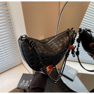 Detalle de bolso hobo de cuero trenzado negro con cuenta de ámbar y correa con nudos