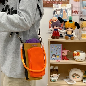 Detail of multi-pocket crossbody bag with orange zipper and purple drawstring closure
