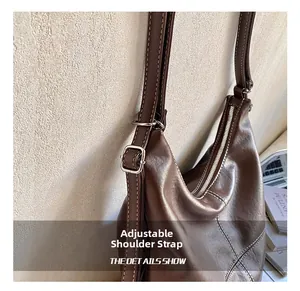 Detail of adjustable shoulder strap with silver buckle on brown tote bag