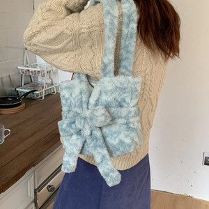 Detailed shoulder view of a light blue plush handbag with a large bow decoration