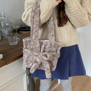Close-up of fluffy plush tote bag featuring a large decorative bow and soft texture