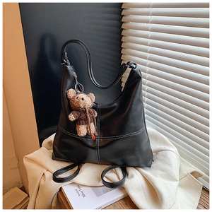 Close-up of black hobo tote bag with white contrast stitching and a cute bear keychain