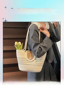 Detail of woven straw beach tote bag featuring a leather flap with pearl embellishment