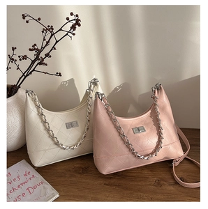 Sacs hobo matelassés en crème et rose poudré avec de grosses chaînes sur table en bois