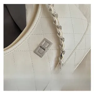 Gros plan détaillé du sac en cuir matelassé blanc avec fermoir en métal argenté et chaîne