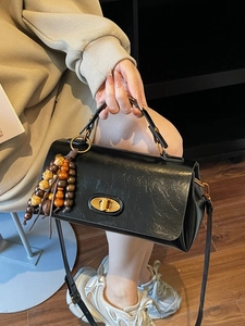 Chic black leather crossbody bag with vintage gold lock and colorful wooden bead tassel