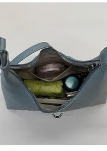 Interno spazioso della borsa hobo blu con tasca con cerniera ed elementi essenziali