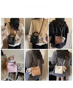 Detail of leather bucket bags with metal lock and plush rabbit charm in five colors