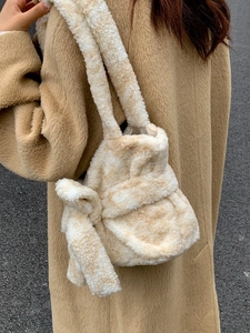 Fashionable plush shoulder bag with large bow detail and soft faux fur texture