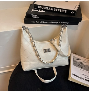 Détail du sac sous le bras matelassé blanc avec chaîne argentée et fermoir rotatif