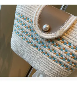 Detail of hand-woven cotton rope bag with brown leather flap and pearl button