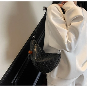 Detail of black woven leather shoulder bag with amber bead and knotted strap design