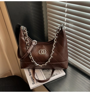 Détail du sac croissant matelassé marron foncé avec chaîne et boucle en métal