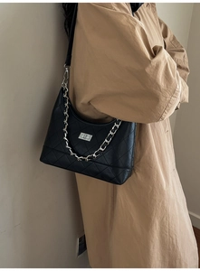 Gros plan d'un sac bandoulière matelassé noir avec chaîne argentée et fermoir rotatif métal