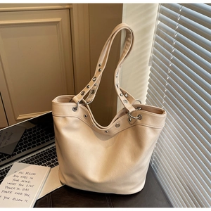 Chic beige large capacity tote bag with silver metal eyelet and rivet details for daily use