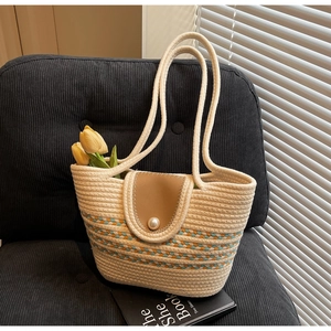 Straw tote bag detail with leather flap, pearl clasp and vibrant colorful woven stripes