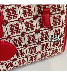 Dettaglio della borsa da sposa rossa con motivi Xi lavorati a maglia e manico in pelle