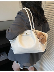 White large capacity tote bag with bear charm shown on a shoulder in a grey blazer