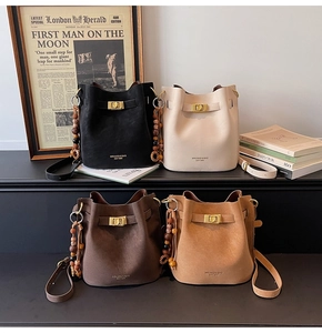 Detail view of four vintage bucket bags in black, beige, coffee, and camel with bead charms